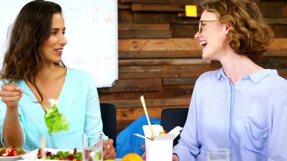 Business executives interacting with each other while having lunch alt