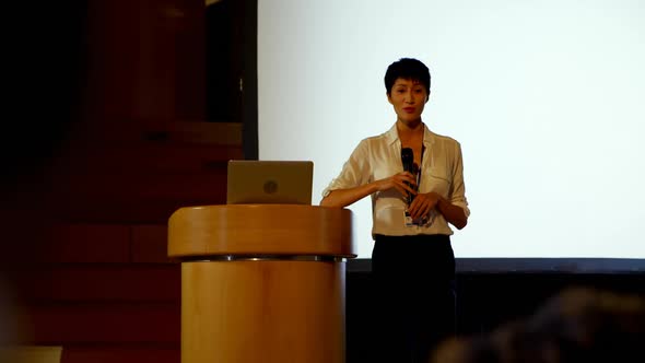 Young Asian businesswoman speaking in business seminar in auditorium 4k alt