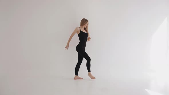 A Beautiful Young Girl is Engaged in Stretching with Elements of Classical Dance and Gracefully alt