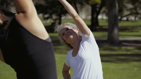 Two Women Talking During Workout in Summer Park. alt