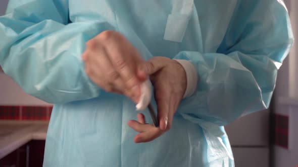 Man in a medical uniform cleaning smartphone screen with sanitizer