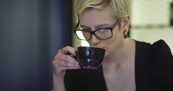 Business Woman Using Laptop While Drinking Coffee in Coffee Shop