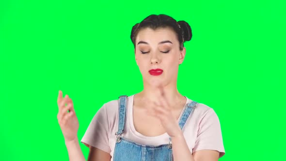 Girl with Two Hair-buns Claps Her Hands Indifferently on Green Screen. Slow Motion alt
