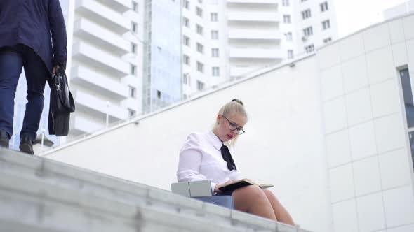 woman makes entries in the diary sitting on the steps