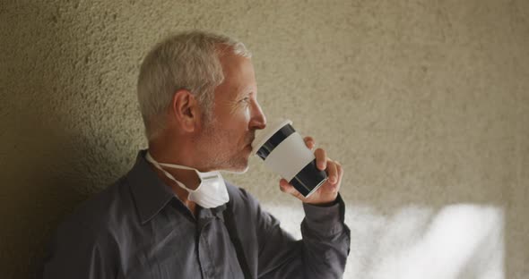 Caucasian man out and about in the street wearing on a face mask against coronavirus alt