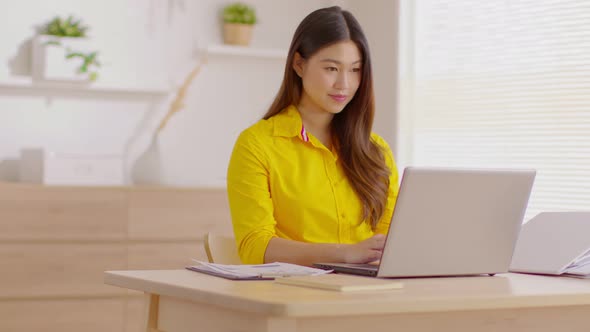 Entrepreneur beautiful business asian young woman wear yellow shirt work online with laptop at home alt