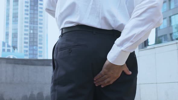 Man Suffering Hemorrhoid Pain, Rubbing Buttocks and Feeling Discomfort, Health