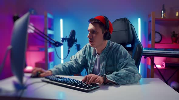 Young Hipster Man Wearing Headphones Playing Computer Game Neon Fashion Room Loser alt