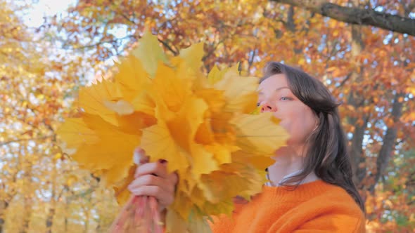 Happy Smiling and Playing with Autumn Leaves Woman
