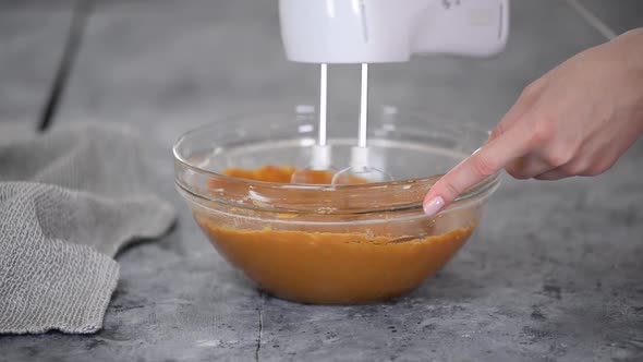 Process of Making the Caramel Dough Woman's Hand Whips Cake Batter