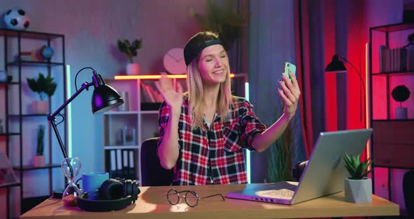 Modern Blondie with Earring in Nose Having Videocall on Mobile with Friend alt