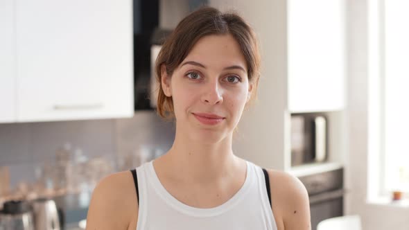 Portrait Footage of Beautiful Caucasian Female Standing on Kitchen in White Shirt Smiling at Camera alt
