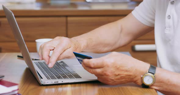 Close Mans Fingers Holding Plastic Credit Card Elderly Man Booking Hotel Using Online App Service alt