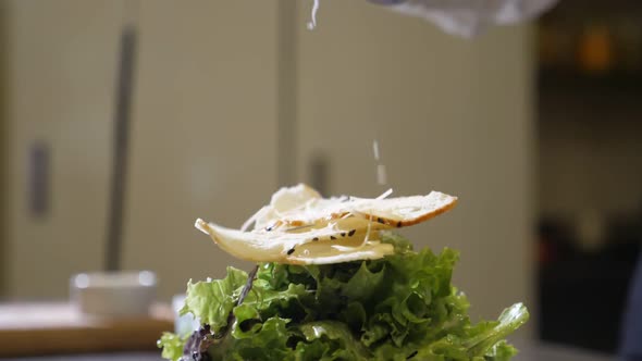 Radish Chips Are Falling on a Salad Dish with Cheese in a Kitchen in Slow Motion