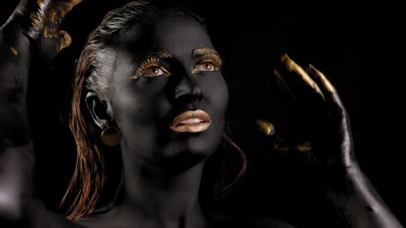 Portrait of a Young Woman with Magical Black Skin and Golden Hands alt