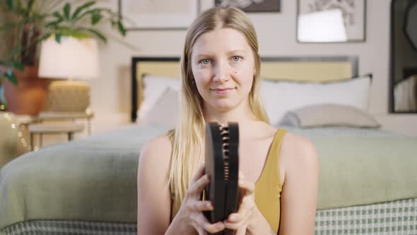 Portrait of a Beautiful Woman Opens and Shows a Sadhu Board Look Into the Camera and Smiles alt