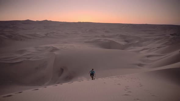 Sunset adventure up a sand dune in the desert while travelling on a gap year, Huacachina, Peru alt