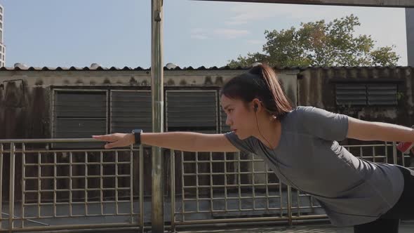 Athlete young Asian woman stretching legs and warming before running a Jogging workout.