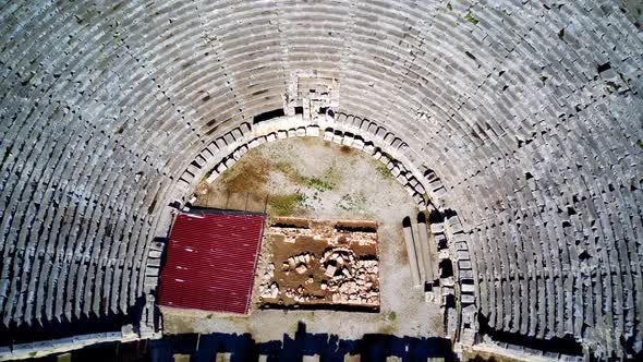 High angle drone aerial view of ancient greek rock cut lykian empire amphitheatre and tombs in Myra alt