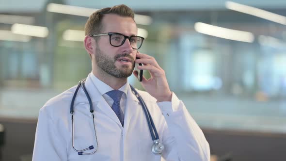 Portrait of Young Male Doctor Talking on Smartphone alt