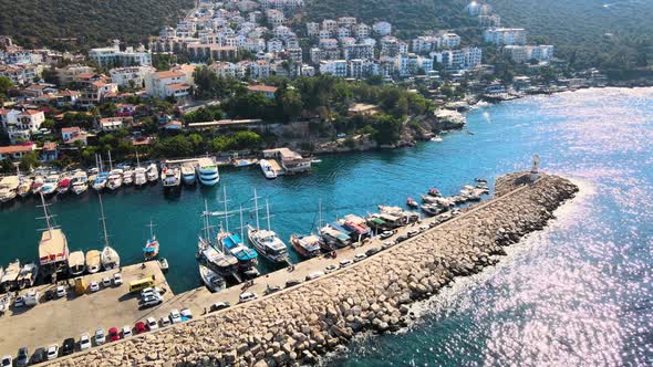 Close-up drone flight over the water surface of the yacht boat mooring against the backdrop of a res alt