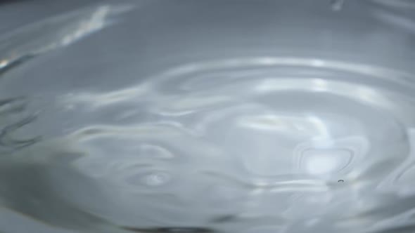 Water Drop Falls on the Water Surface in Slow Motion Macro Shot alt