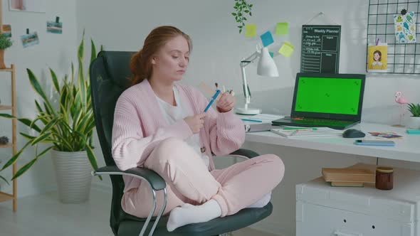 Procrastinating Female Designer Making an Airplane Out of a Ruler and a Pen alt