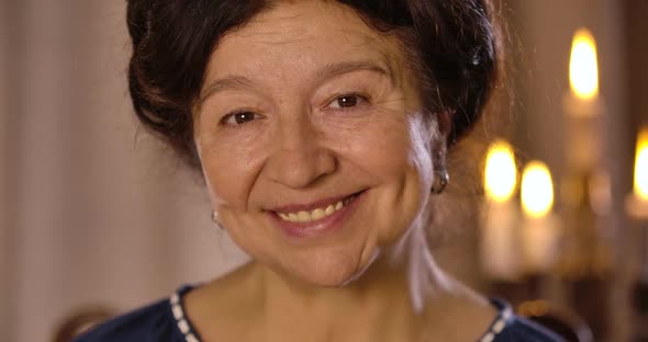 Close-up Portrait of Smiling Mature Caucasian Woman Looking at Camera and Talking alt