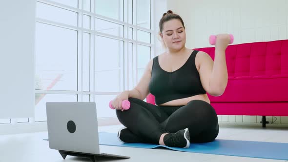 Overweight young woman in sportswear exercising to lose weight at home alt