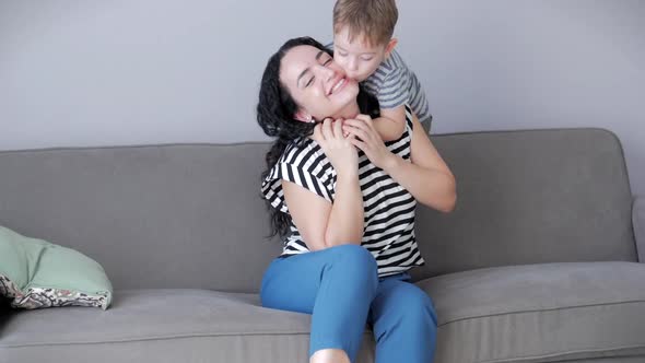 Happy Healthy Family Young Mom Lifting Cute Little Child Son Up Playing Plane on Sofa at Home, Funny alt