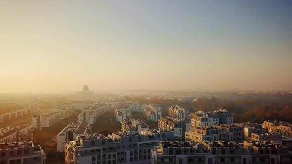 Beautiful cinematic aerial shot of misty sunrise in foggy town in autumn