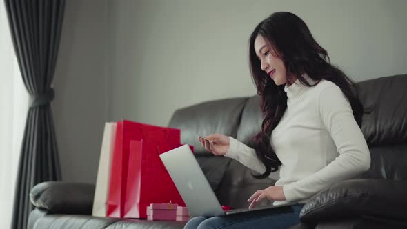 woman shopping online for gift with laptop in the living room