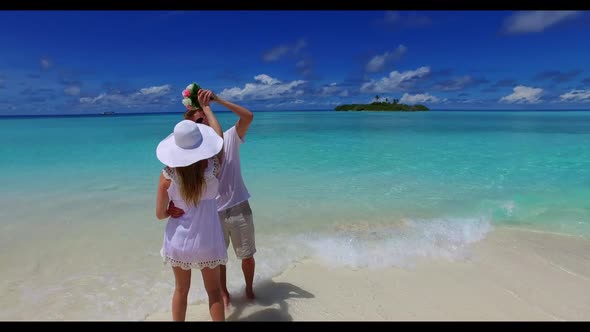 Teenage lovers in love on exotic coast beach trip by aqua blue water and white sandy background of t alt