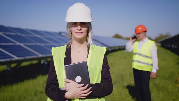 Portrait of Two Engineers in Special Uniforms with Protective White Helmets alt