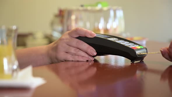 Close-up of female hands holding a terminal in a cafe, restaurant, store alt