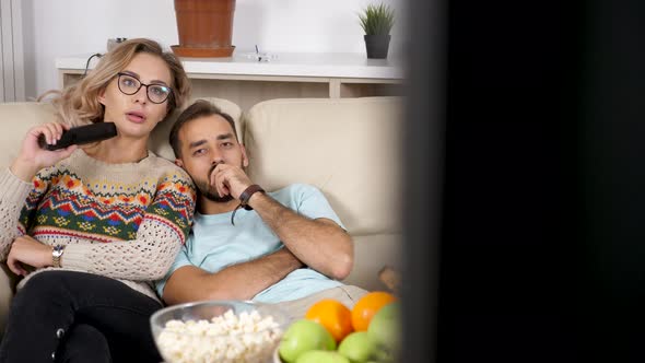 Revealing Shot Couple Sitting on the Couch Talking, Eating Popcorn and Watching TV alt