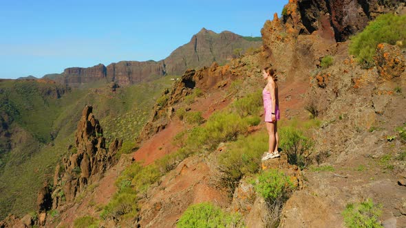 Young Beautiful Woman Enjoys the View of the Gorge From the Top of Mountain Sunset alt
