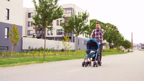 Father with Stroller Calling on Smartphone in City alt