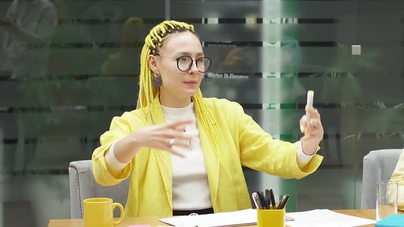 Closeup a Young Woman with Yellow Pigtails a Woman Sitting at a Desk in the Office and Telling
