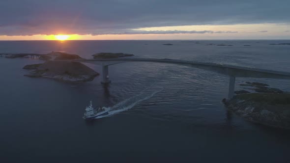 Atlantic Ocean Road in Norway at Sunset. Ship Is Passing Under Storseisundet Bridge. Aerial View alt
