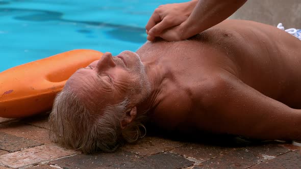 Lifeguard helping unconscious senior man alt