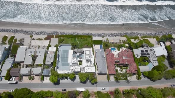 Drone flying over houses, beach and ocean waves in Malibu, California, USA alt