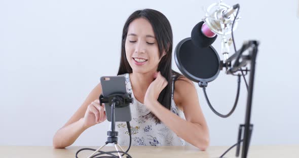 Woman having live stream on cellphone  alt