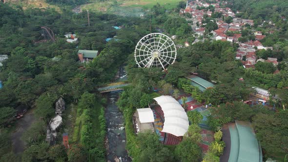 Aerial view of Ferris wheel and roller coaster rides at pier pacific park at sunset.