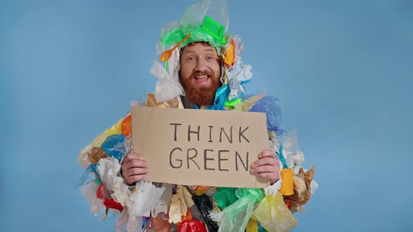 Man dressed in garbage costume holding cardboard plate. 