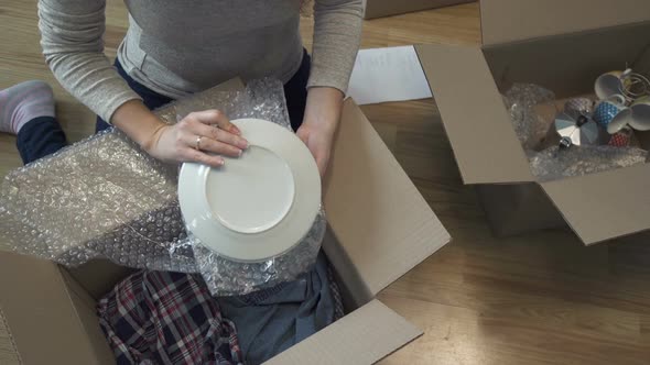 A Woman Unpacks Boxes After Moving To a New Apartment