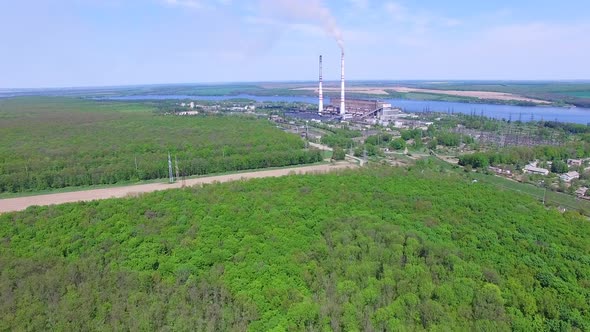 Power station with pipes. Aerial view of smoke and steam from high chimney of power plant alt