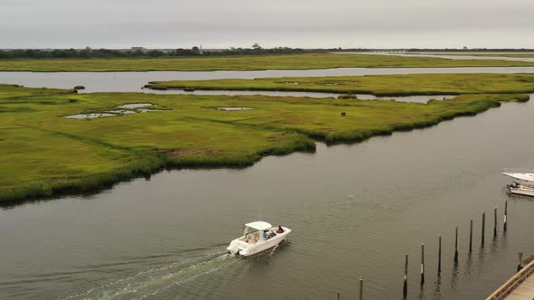 An aerial view of a fishing boat sailing in Freeport, NY. The camera truck right, orbiting around th alt