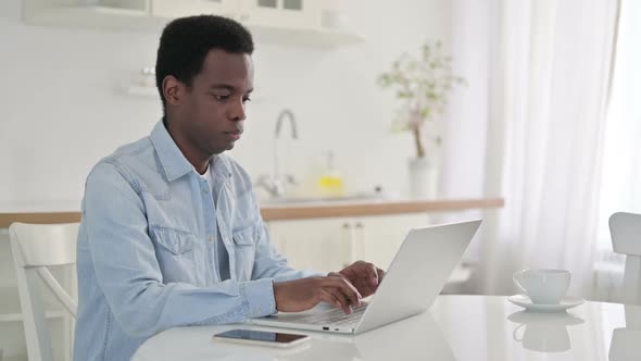 African Man with Laptop Looking at the Camera alt