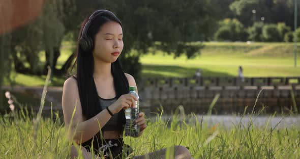 Young Attractive Asian Woman Student Listening to Music and Study with Green Tree Garden in